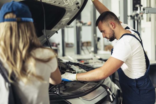 Personas trabajando en mantenimiento de coche